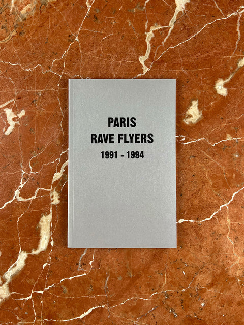 Book titled 'Paris Rave Flyers 1991-1994' on a marble background